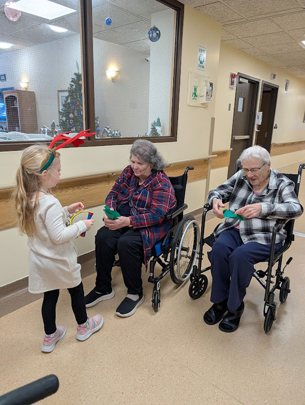 Student greets elders in wheelchairs