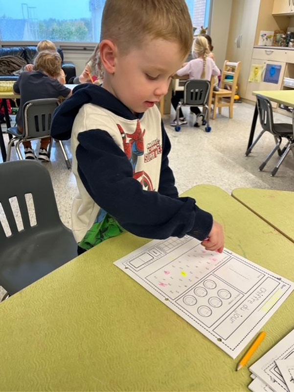 A boy working on a worksheet at his desk