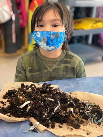A pile of vermicompost on the table in front of a student
